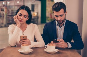 Pareja mirando sus móviles sin hablar