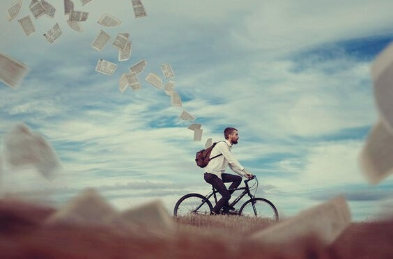 chico en bici dejando ir papeles simbolizando esos momentos cuando nadie cree en ti