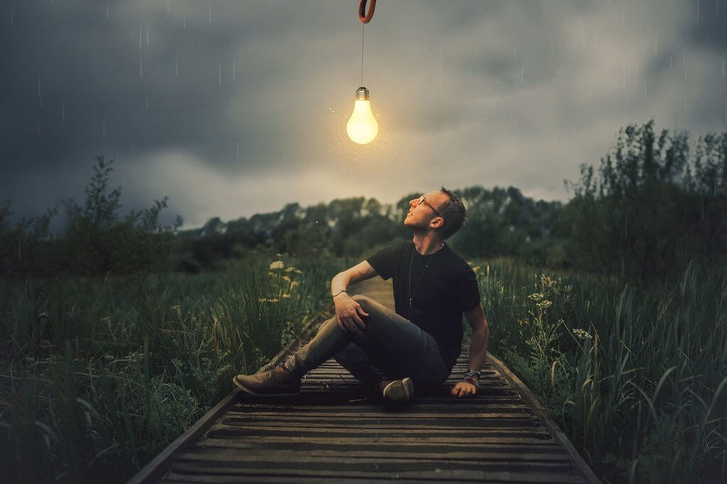 Chico mirando una bombilla que prende