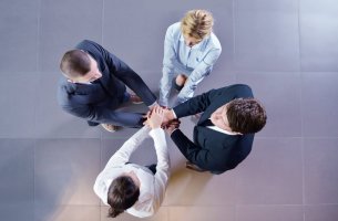 Grupo de personas uniendo sus manos para representar el concepto de confianza social