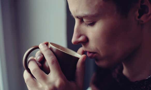hombre con taza en la mano disfrutando del olor a café