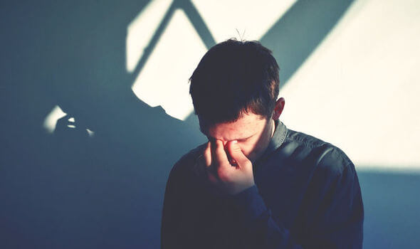 Hombre triste con la mano en el rostro