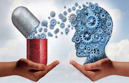 Manos con una pastilla y el perfil de la cabeza de una persona para representar los efectos de las benzodiacepinas