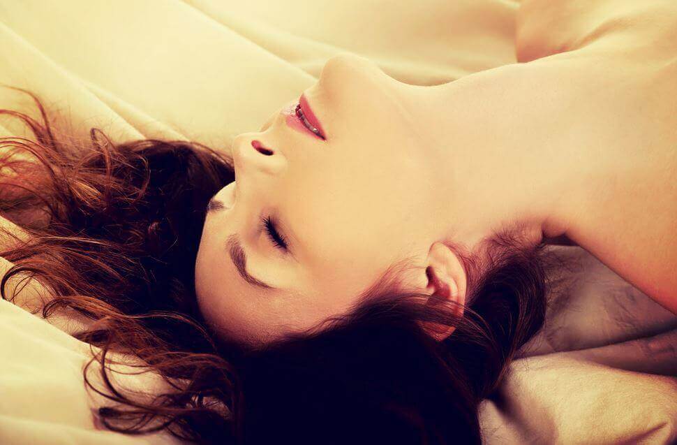 Mujer con los ojos cerrados en la cama