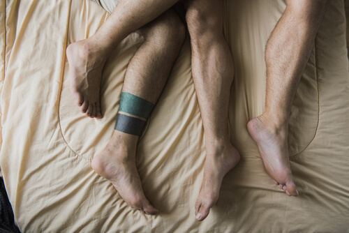 Piernas de hombres en la cama