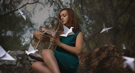 chica con jaula de pájaros cansada de gustar y agradar