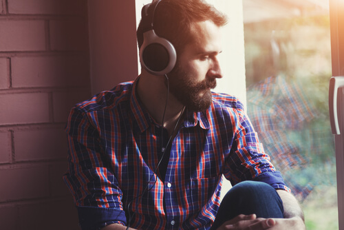 boy listening to music and thinking of saying goodbye