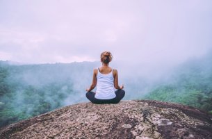 Mujer meditando en una montaña