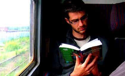 chico en tren para representar los beneficios de leer mientras viajamos