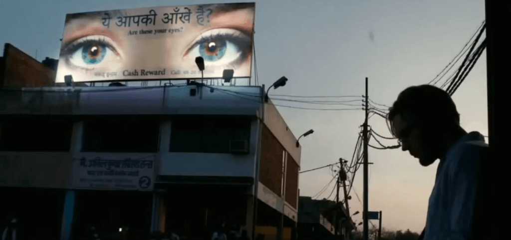 Hombre frente a un cartel con ojos