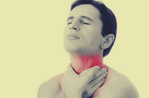mann som berører halsen fordi han lider av globusfølelse