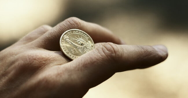Mano con una moneda