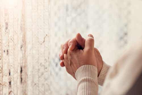Manos de una persona mayor rezando