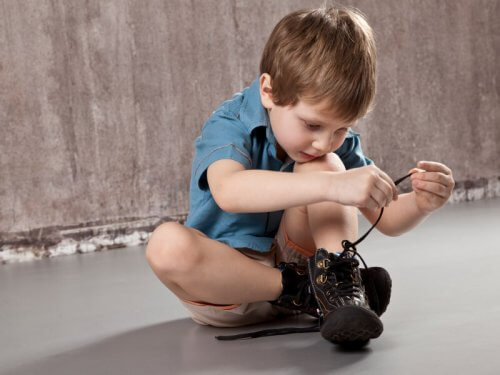 Niño atándose los cordones de los zapatos