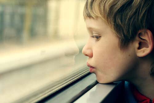 Niño autista mirando por la ventana
