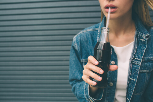 Adolescente bebiendo refresco azúcarado