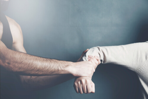 Hombre agarrando el brazo a una mujer