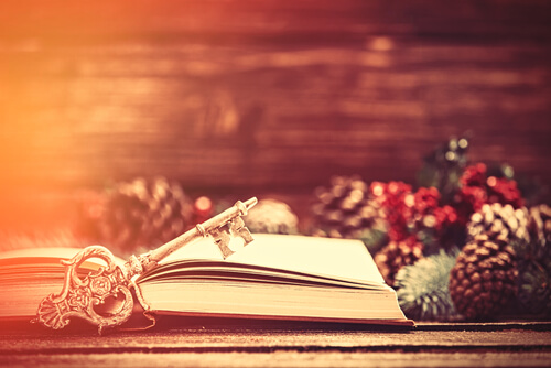 Libro abierto con una llave junto a decoración navideña
