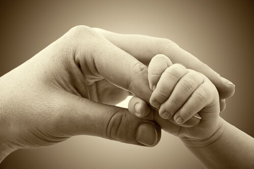 Bebé cogiendo la mano de su madre