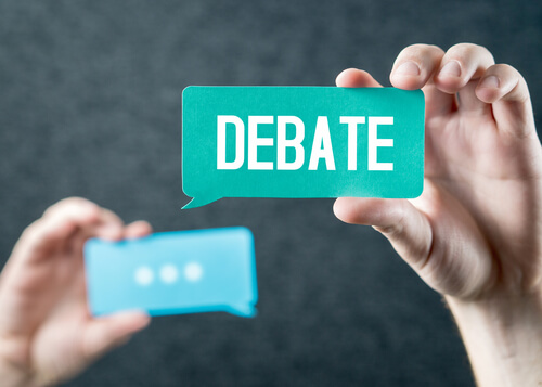 Mano sujetando el cartel con la palabra debate
