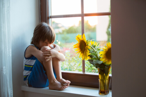 Niño triste en la ventana