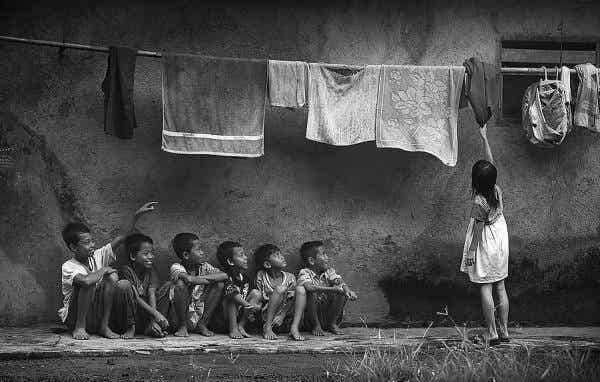 Niños mirando a una niña coger ropa