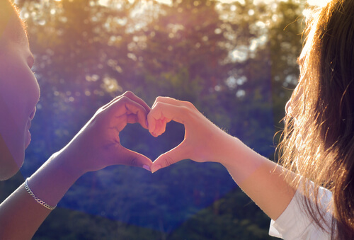 Amigas haciendo una forma de corazón con las manos