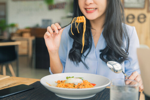 Mujer comiendo pasta