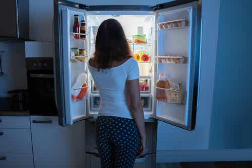 Mujer con síndrome de ingesta nocturna delante del frigorífico