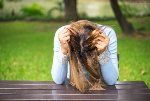 Mujer con malestar agarrándose la cabeza
