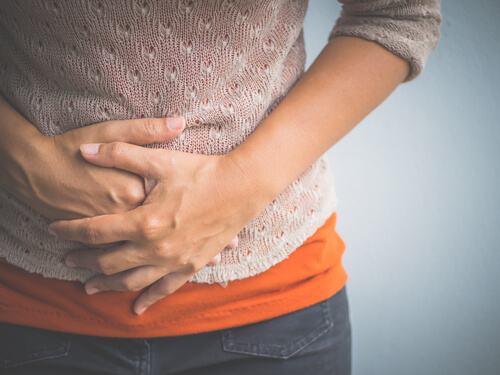 Mujer con manos en la barriga por dolor menstrual