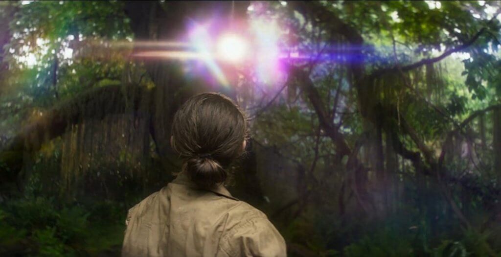 Mujer mirando una luz entre árboles
