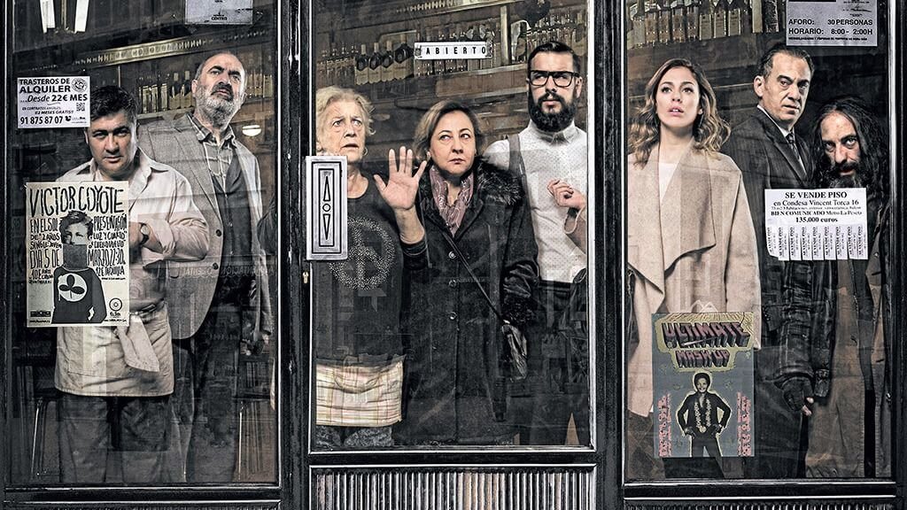 Personas asomadas tras los cristales de un bar