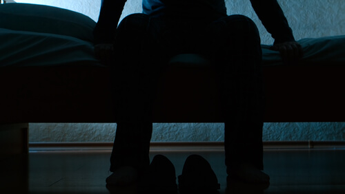 Hombre sentado en una cama