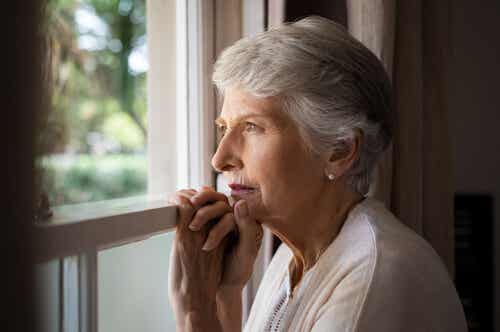 Mujer con demencia mirando por la ventana