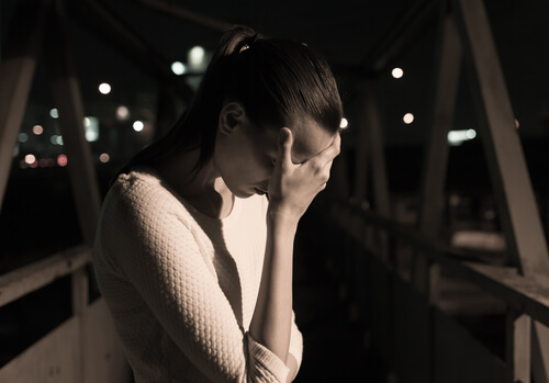 Mujer triste en un puente sintiendo la culpa
