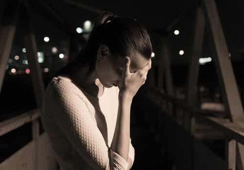 Mujer triste en un puente sintiendo la culpa