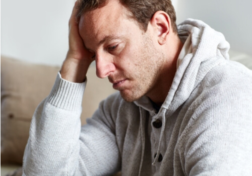 Hombre maltratado triste pensando en cómo se trata el sufrimiento en terapia psicológica