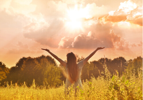 Mujer con los brazos abiertos al aire libre
