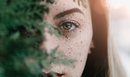 mujer tras rama de árbol representando el carácter fuerte y la resiliencia