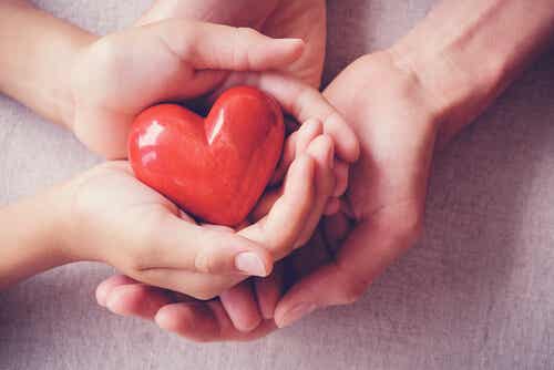 Manos sujetando un corazón para representar la importancia de los cuidados