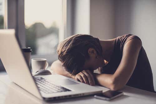 Mujer con estrés con la cabeza apoyada en el ordenador