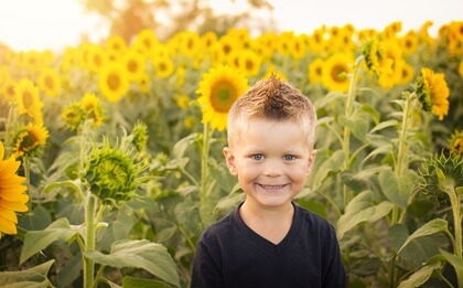 Pequeño entre girasoles representando a los niños asertivos
