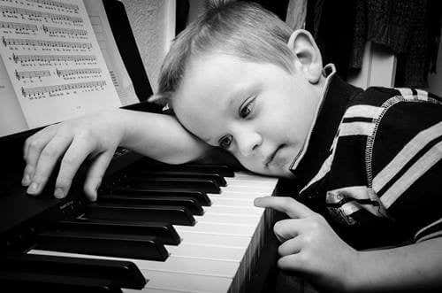 niño desanimado al piano