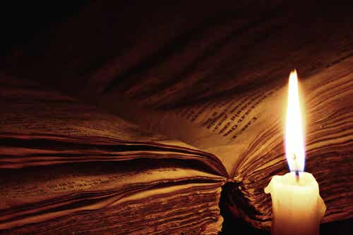 Libro abierto con una vela encendida
