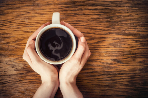 Manos de una mujer con una taza de café