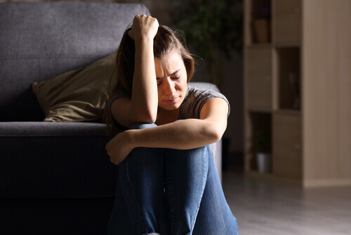 Mujer triste sentada en el suelo