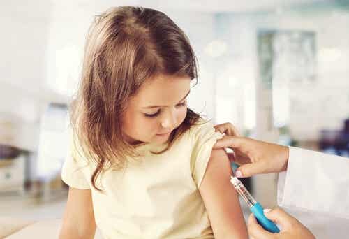 Enfermera poniendo una vacuna a una niña