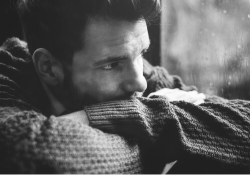 Hombre pensando mirando por la ventana