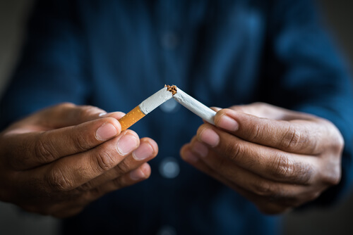 Hombre rompiendo un cigarrillo